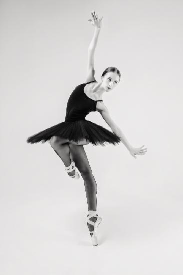 black swan. ballerina in a black tutu shows elements of ballet dance in motion