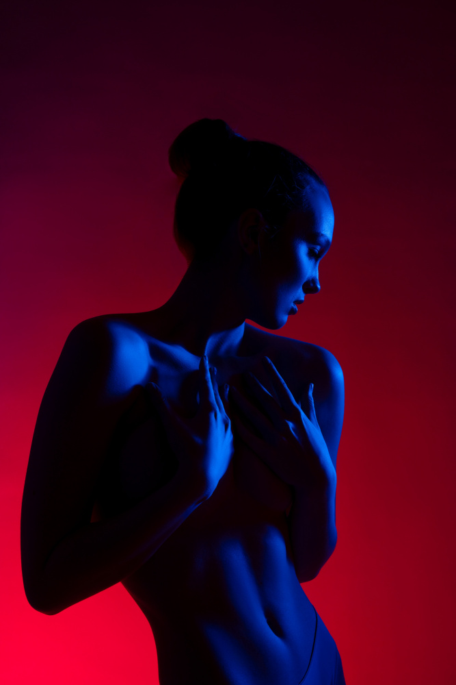 Young woman in casual clothes standing under neon light van Andrey Guryanov
