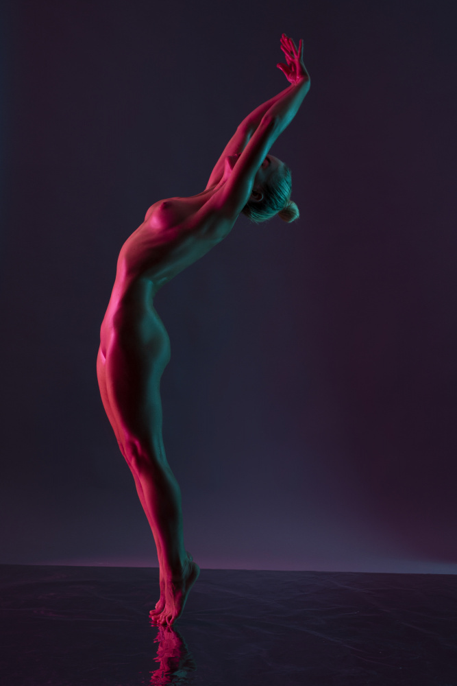 Young naked woman dance against dark purple background van Andrey Guryanov