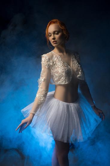 Beautiful young ballerina in blue haze