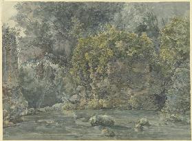 Baumlandschaft mit verfallenem Gemäuer an einem Bach