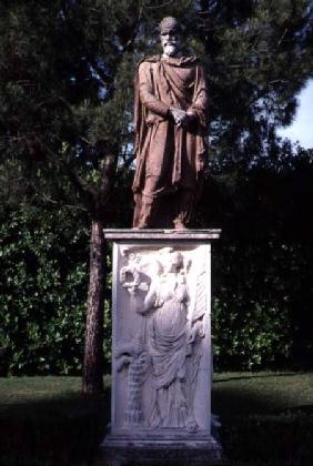 View of the garden detail of a travertine sculpture of a male figure on a marble relief decorated wi