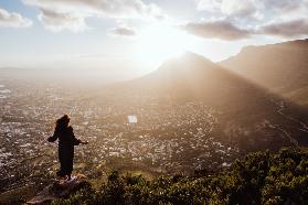 Sonnenaufgang über Kapstadt auf dem Lions Head mit einer Frau